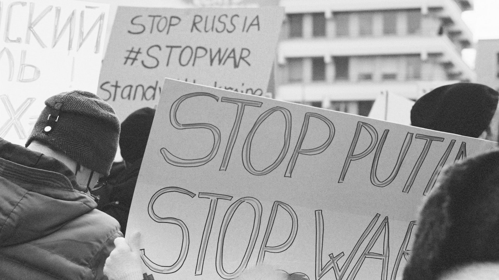 An image of protesters holding up signs about the Ukraine war. Signs say "Stop Russia. #Stopwar. Stop Putin." and more.