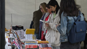 A group of people standing beside a display table of books
