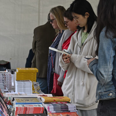 A group of people standing beside a display table of books