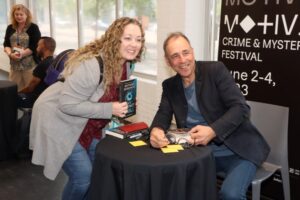 Anthony Horowitz posing for a photo with a fan at MOTIVE 2023.