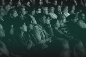 An audience is captivated by something on stage