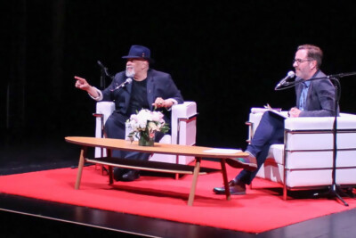 Walter Mosely on stage with Roland Gulliver during MOTIVE 2024. Walter is pointing out into the audience