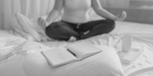 Photo of woman meditating with open journal