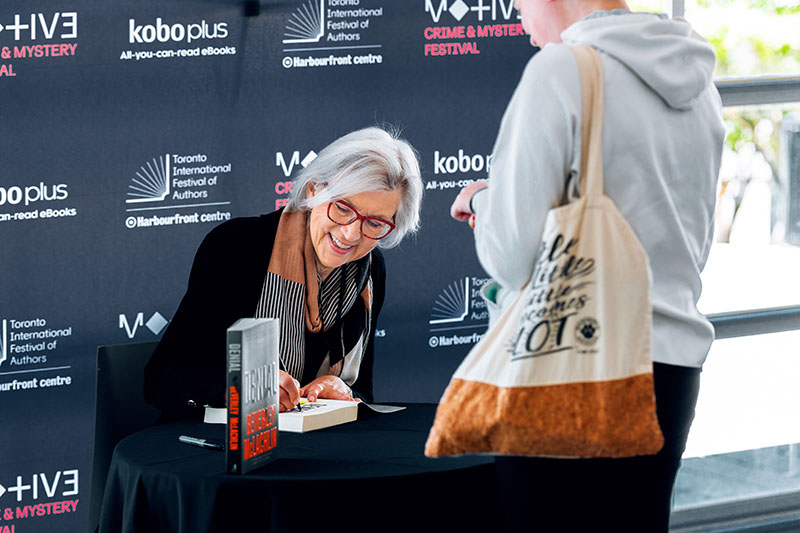 Portrait of woman signing a book